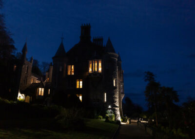 old gothic building against a dark blue night skyguests dancing to music on a dance floor by Anglesey wedding photographer Gill Jones Photography