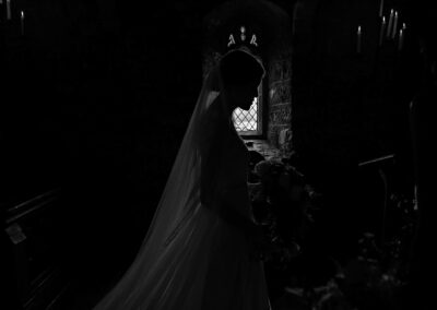 silhouette of a bride as she passes by a window by Anglesey wedding photographer Gill Jones