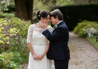 bride rests her forehead against the groom's as he brings his hand towards her chin by Anglesey wedding photographer Gill Jones