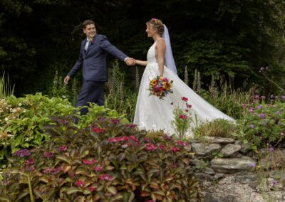 groom leading bride whilst turning towards her by Anglesey wedding photographer Gill Jones