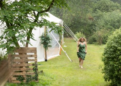 Bridesmaids run through the rain from a marquee towards the big house by Anglesey Photographer Gill Jones Photography