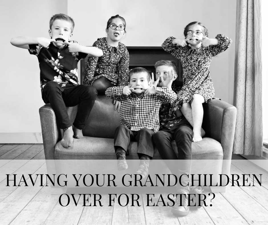 five children piled on a settee pulling face by anglesey family photographer Gill Jones