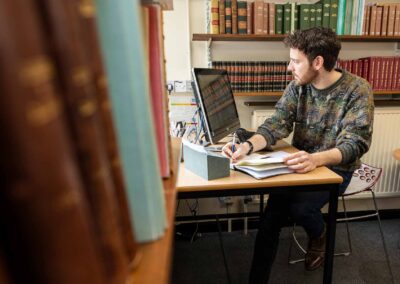 a man writes in his notebook whilst looking at a monitor by north wales commercial photographer Gill Jones Photography