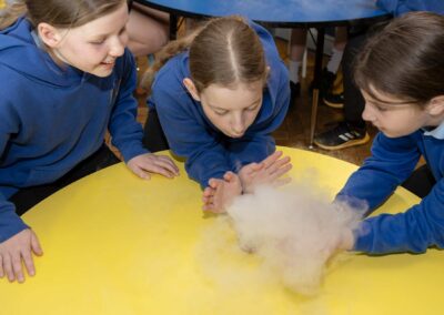 three school girls taking part in an experiment for Science week sponsored by The National Grid in Llanberis