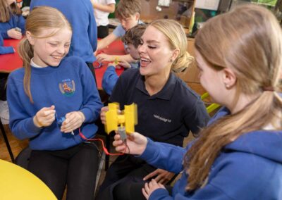 an engineer laughs whilst helping school children with a science experiment by north wales commercial photographer Gill Jones Photography
